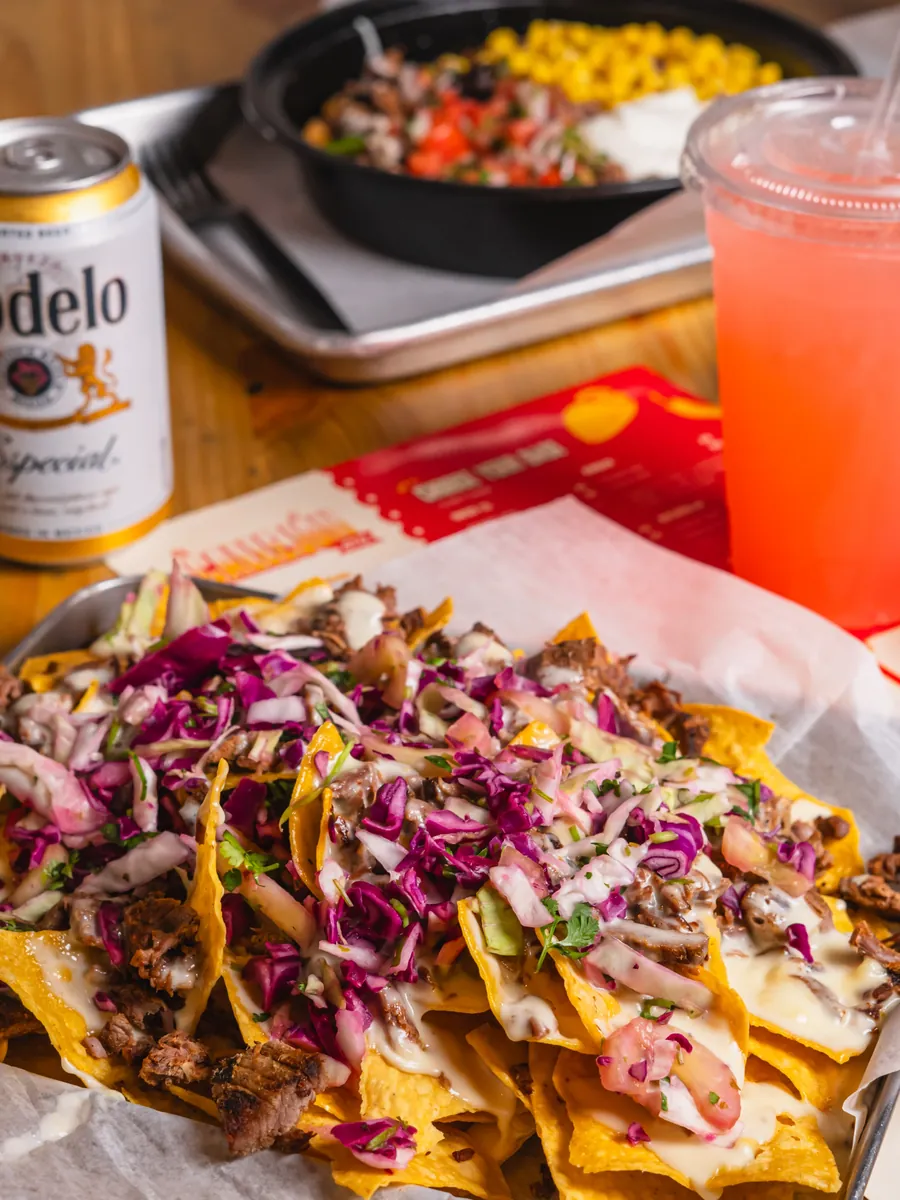 Nachos topped with meat, cheese and red cabbage