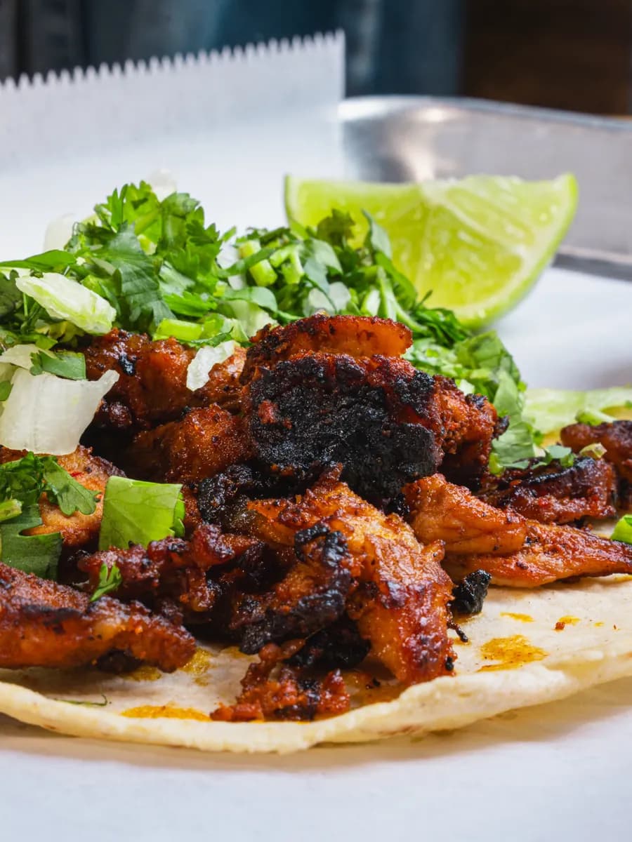 Al pastor tacos on a metal tray